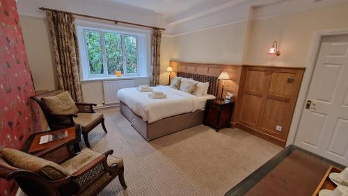 ein Schlafzimmer mit einem Bett, einem Stuhl und einem Fenster in der Unterkunft Ambleside Manor - Vegetarian B&B in Ambleside