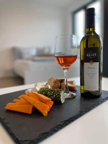 a bottle of wine and a plate of cheese and a glass at Mikuloff in Mikulov