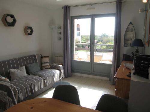 a living room with a couch and a sliding glass door at Appartement Saint-Cyprien, 3 pièces, 6 personnes - FR-1-106-44 in Saint-Cyprien
