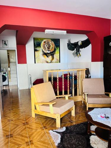 a living room with two chairs and a wall with a painting at Casa BB&Djassi in Ponta do Sol