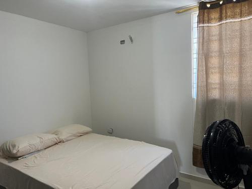 um quarto com uma cama e uma janela com uma ventoinha em Habitacion valledupar em Valledupar