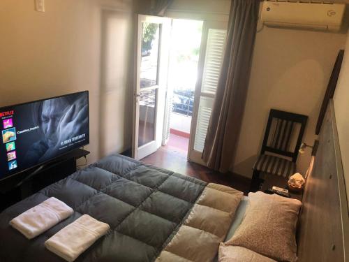 1 dormitorio con 1 cama y TV de pantalla plana en CasaFélix en Mendoza