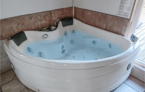 un bagno con vasca e vasca idromassaggio con un bagno tubificialificialificialificialificiale di Amazing Home In Kpingsvik With Sauna a Köpingsvik
