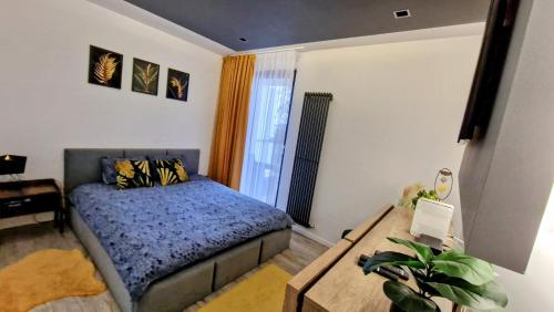 Un dormitorio con una cama y una mesa. en Apartament SZWEDZKA z duzym 30m Tarasem i garażem podziemnym en Kielce