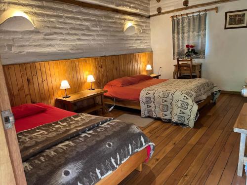 Duas camas num quarto com pisos em madeira em Hostería Hotel Cuello de Luna - Cotopaxi - Country Inn em Lasso