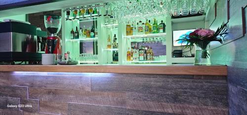 a bar with glasses and flowers on the counter at Villa Bonaca in Vukovar