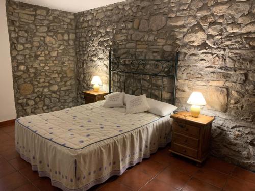 a bedroom with a bed and two lamps on tables at Casa Altemir in Campo
