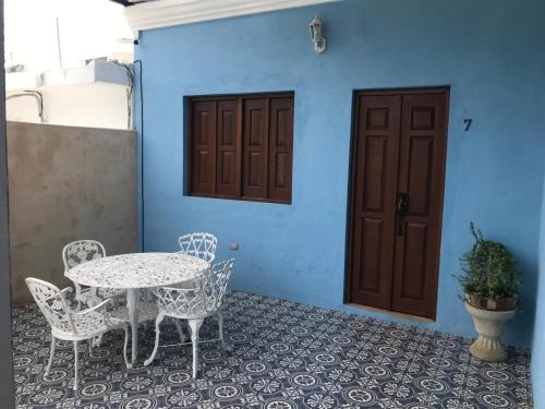 a patio with a table and chairs and a door at Boutique Casa Azuli Santiago in Mérida