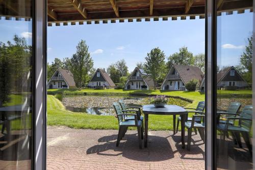 a patio with a table and chairs and a view of houses at De Vecht, 124 - centraal gelegen aan vijver in Gramsbergen