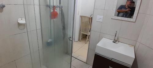 a man taking a picture of a bathroom with a shower at Apartamento Na Ilha Porchat in São Vicente