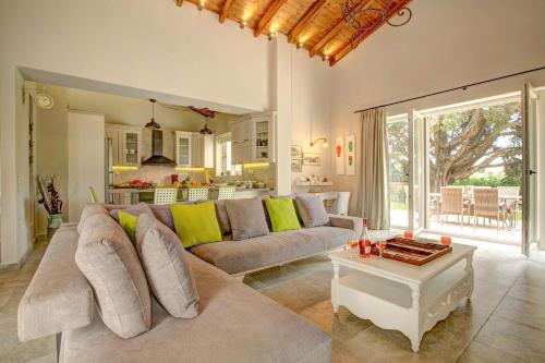 a living room with a couch and a table at Astarte Villas - Laalu Private Villa with Pool in Koukounariá