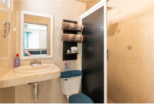 y baño con lavabo, aseo y espejo. en Casa paz, en Isla Mujeres