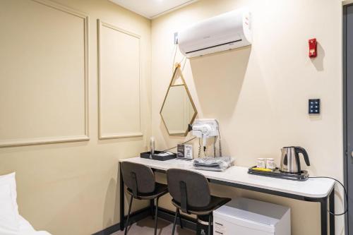 a room with a desk with two chairs and a mirror at Hotel Rodem in Incheon