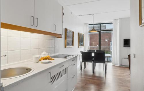 cocina blanca con fregadero y mesa en 1 Bedroom Stunning Apartment In Fan, en Fanø