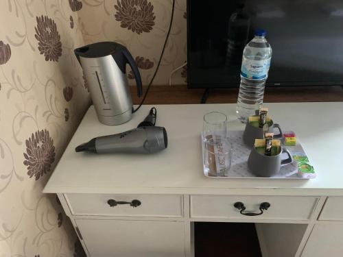 a table with a coffee maker and a water bottle on it at Le Pontet in Miramont-de-Guyenne