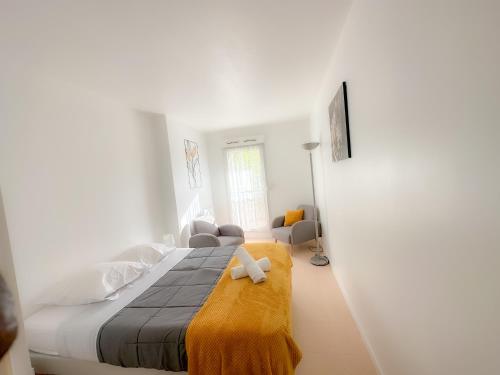 a bedroom with a large bed with a yellow blanket at Mai Linh - TiAM CONCIERGERIE-Disney-VILLIERS SUR MARNE CENTRE VILLE in Villiers-sur-Marne