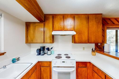 a kitchen with wooden cabinets and a white stove top oven at Huntington Lake Condo #38 in Lakeshore