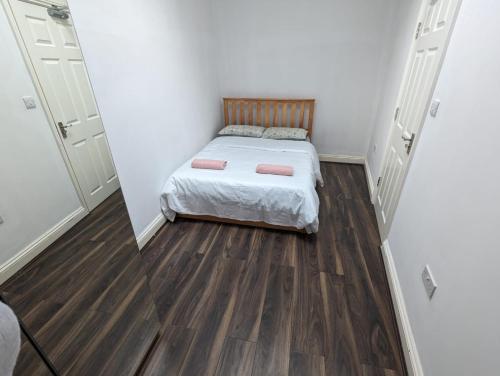 Habitación pequeña con cama y suelo de madera. en RAHAL BARNET en Barnet