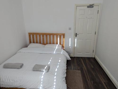 a bedroom with a white bed with two towels on it at RAHAL BARNET in Barnet