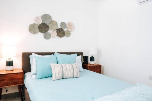 a bedroom with a bed with blue pillows at Casona Apt 3 @ Ocean Park / 3 min Walk to Beach - Nuevo in San Juan