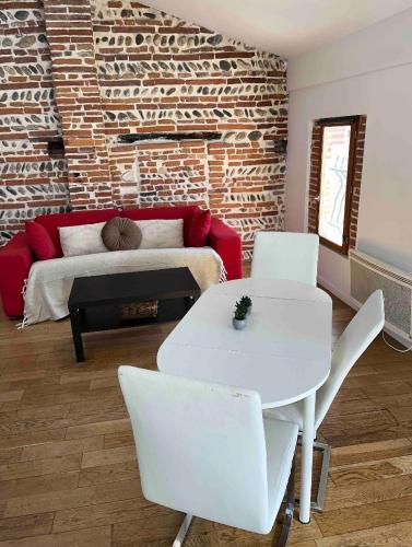 - un salon avec un canapé, une table et des chaises dans l'établissement Appartement de charme Toulouse nord, à Aucamville