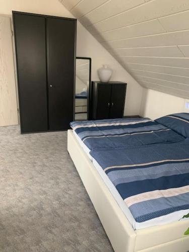 a bedroom with a large bed and a black cabinet at Ruhiges Einzimmer-Apartment in Backnang