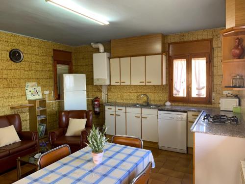 eine Küche mit einem Tisch und einem blauen Tischtuch darauf in der Unterkunft Cal Serveró in Peramola