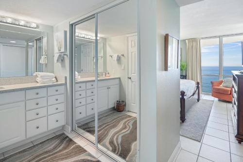 a bathroom with a walk in shower and a glass door at Perdido Sun Resort 1108 by PKRM in Pensacola