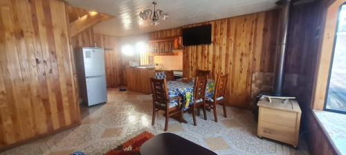 a kitchen with a table and chairs and a refrigerator at cabaña pucón in Pucón