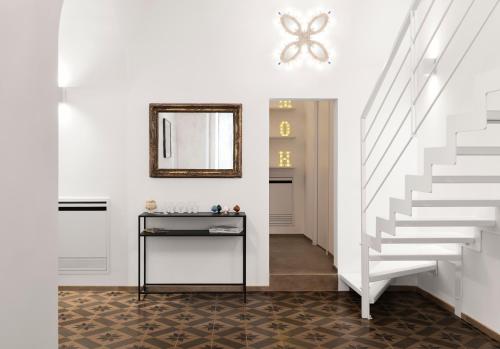 pasillo con escaleras blancas y espejo en MOH - Casa Vacanze, en Grottaglie