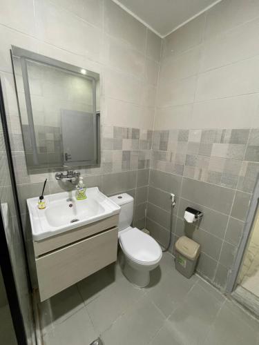 y baño con aseo, lavabo y espejo. en Oskar Appartment, en Wadi Musa