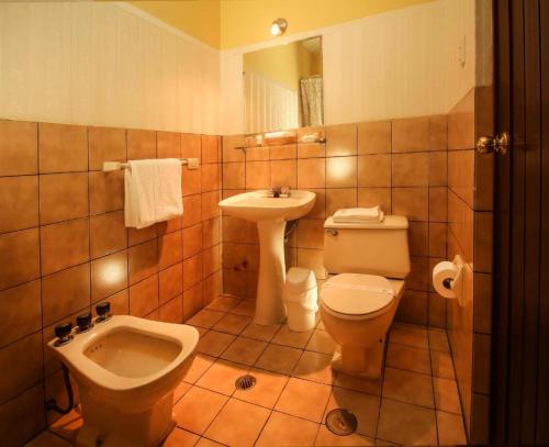 y baño con aseo y lavamanos. en Hotel Meliana, en Arequipa