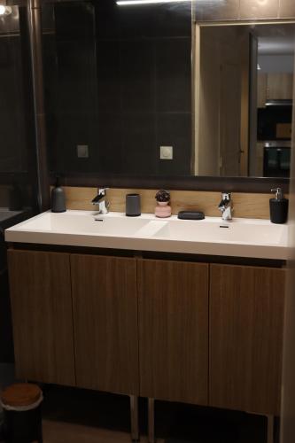 a bathroom with two sinks and a large mirror at Appartement, Lumières d'Arcachon in Arcachon