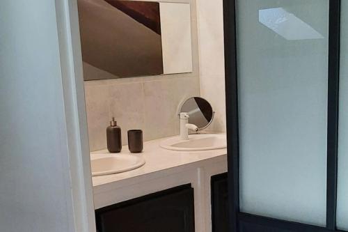Baño con 2 lavabos y espejo en Mon appart Teranga en Périgueux