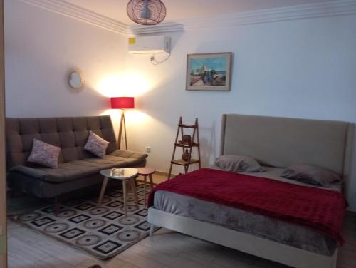 sala de estar con cama y sofá en appartement S+0 en Túnez