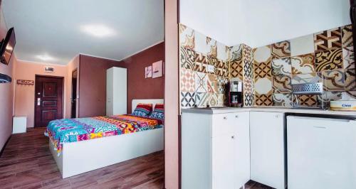 a bedroom with a bed and a kitchen in it at Garsonierele Alexandru in Saturn