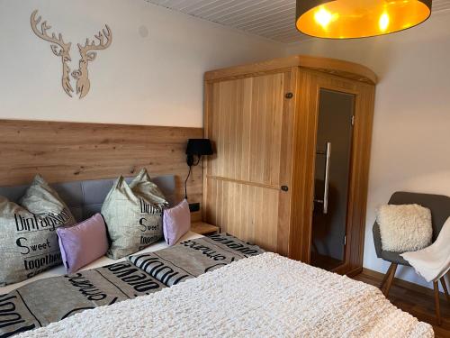 una camera da letto con un letto con cuscini sopra di Ferienwohnungen am Riedanger a Mayrhofen
