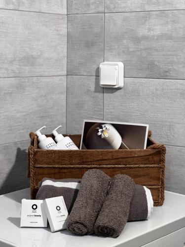 a basket of towels on a shelf in a bathroom at Thèros in Ermoupoli