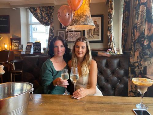 two women sitting at a bar with glasses of wine at Kings Arms Hotel in Ulverston