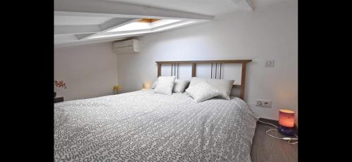 a bedroom with a large white bed with pillows at SUPERBE 2P MEZZANINE AU COEUR DU VIEIL ANTIBES in Antibes