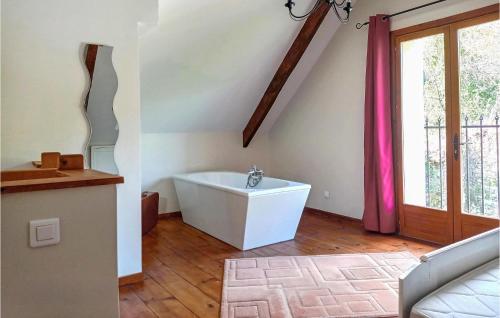 ein Bad mit einer weißen Badewanne in einem Zimmer mit einem Fenster in der Unterkunft Nice Home In Sglien With Wi-fi in Séglien