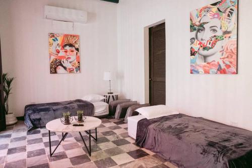 ein Hotelzimmer mit 2 Betten und einem Tisch in der Unterkunft Art Inspired Apt Besides Governors Mansion in OSJ - Fort Apt 11 in San Juan
