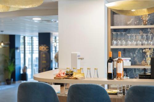 a table with a plate of food and bottles of wine at The Originals Résidence Aix Schuman in Aix-en-Provence