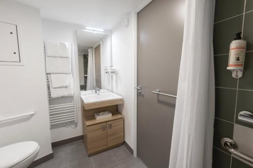 a bathroom with a sink and a toilet and a shower at The Originals Résidence Aix Schuman in Aix-en-Provence