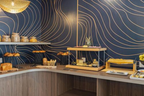 a bakery with a counter with bread and pastries at The Originals Résidence Aix Schuman in Aix-en-Provence