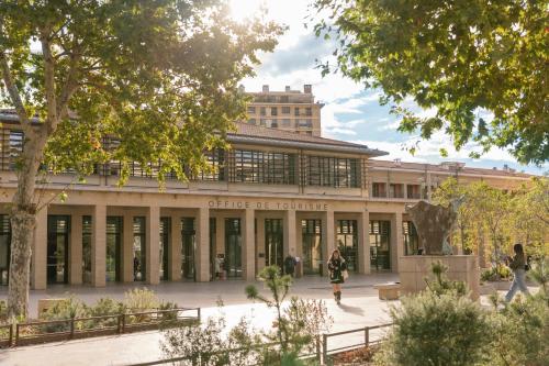 a building with a statue in front of it at The Originals Résidence Aix Schuman in Aix-en-Provence