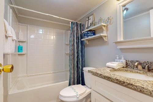 a bathroom with a toilet and a sink and a shower at IR 110: Seas the Day Port A: 2BR, 2BA, Shared Pool, Boardwalk to Beach, Golf Cart Access in Port Aransas