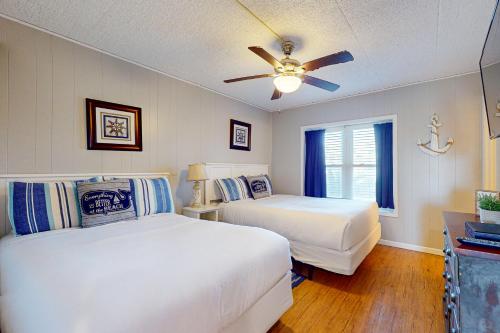 a bedroom with two beds and a ceiling fan at IR 110: Seas the Day Port A: 2BR, 2BA, Shared Pool, Boardwalk to Beach, Golf Cart Access in Port Aransas