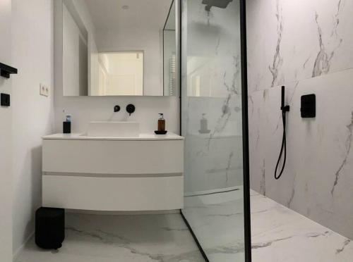 ein weißes Badezimmer mit Waschbecken und Dusche in der Unterkunft Beautiful Sunny Penthouse (near Place Albert) in Knokke-Heist