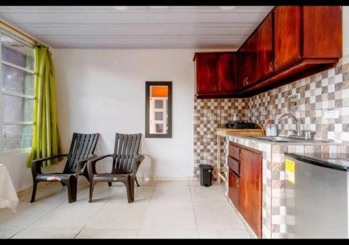 eine Küche mit zwei Stühlen und einem Tisch darin in der Unterkunft Hostal Cartagena Beach in Cartagena de Indias